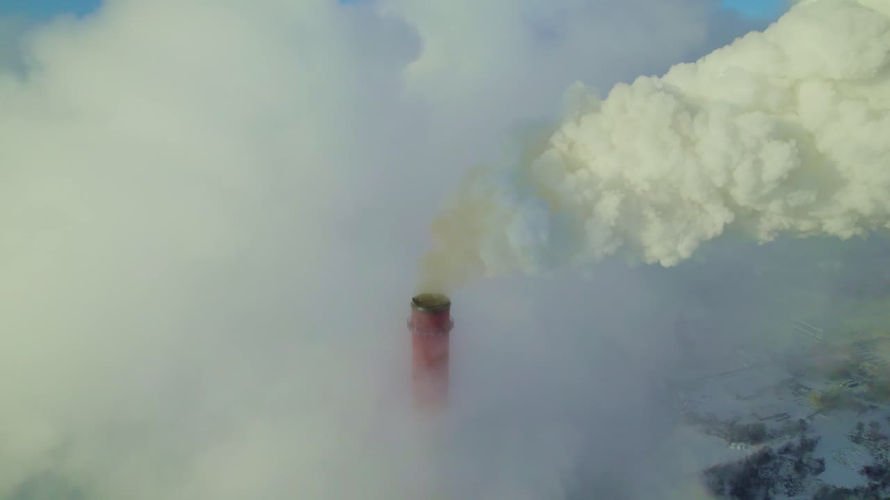 Aerial view of a power plant emitting smoke on a cold winter day