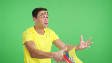 nervous man cheering for ecuador during a match looking away