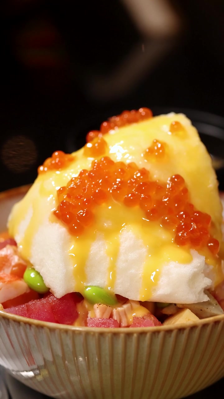 Menaburkan Kaviar Ikura ke atas Mangkuk Poke Jepang Gourmet dengan Telur Mengembang.