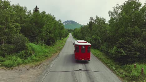 Trolley-Driving-Through-Empty-Road-Between-The-Forest-In-Anchorage,-Alaska