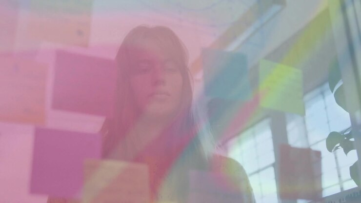 Vertical video: Woman behind notes on glass for design, prism band drifting causing head tilts