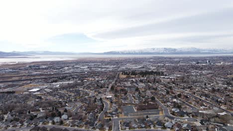 aerial shot of provo city suburbs, utah lake and mountains in background