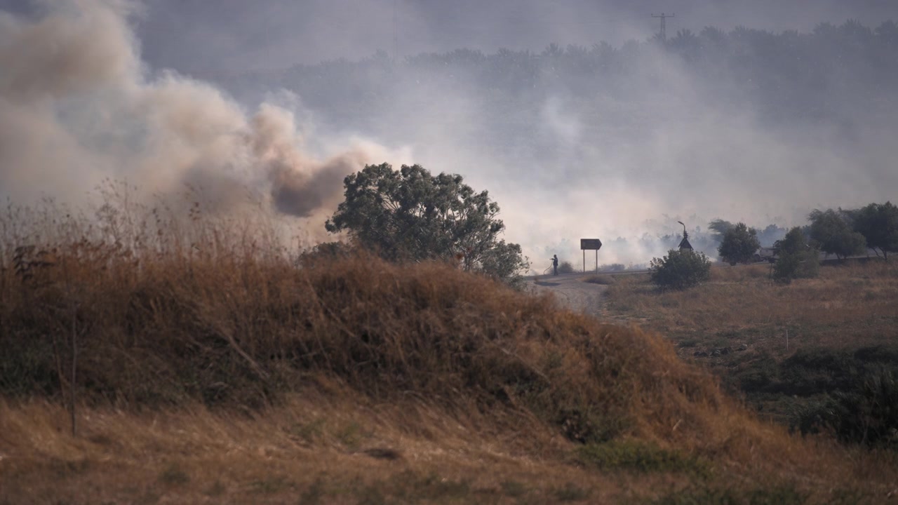 Un pompiere cerca di spegnere l'incendio boschivo.