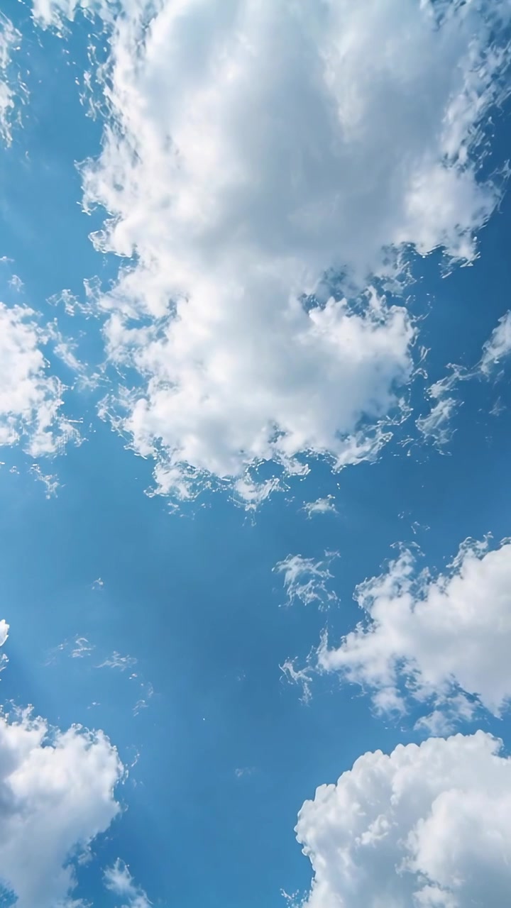 Video verticale: Telefono inclinato che riprende una grande nuvola cumuliforme che si muove nel cielo in formato verticale, spinta dalla brezza.