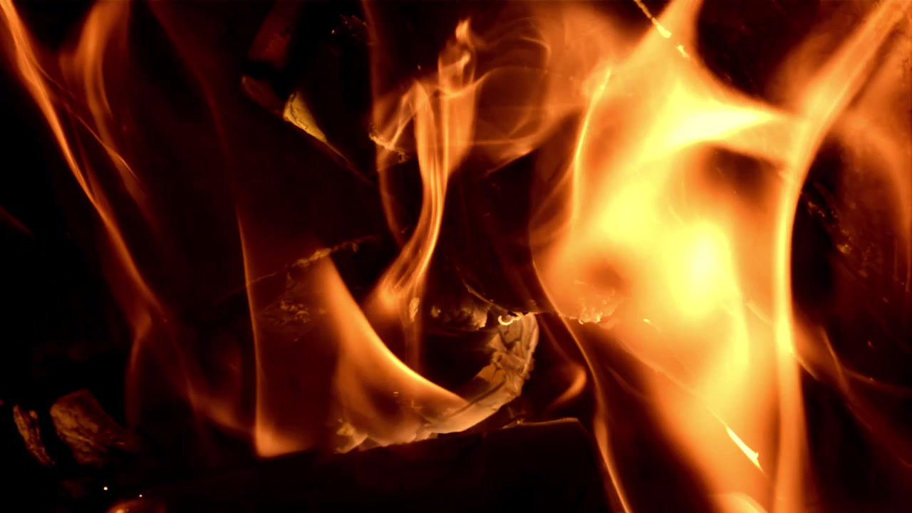 Fiamme di fuoco astratte che bruciano al rallentatore su sfondo scuro.