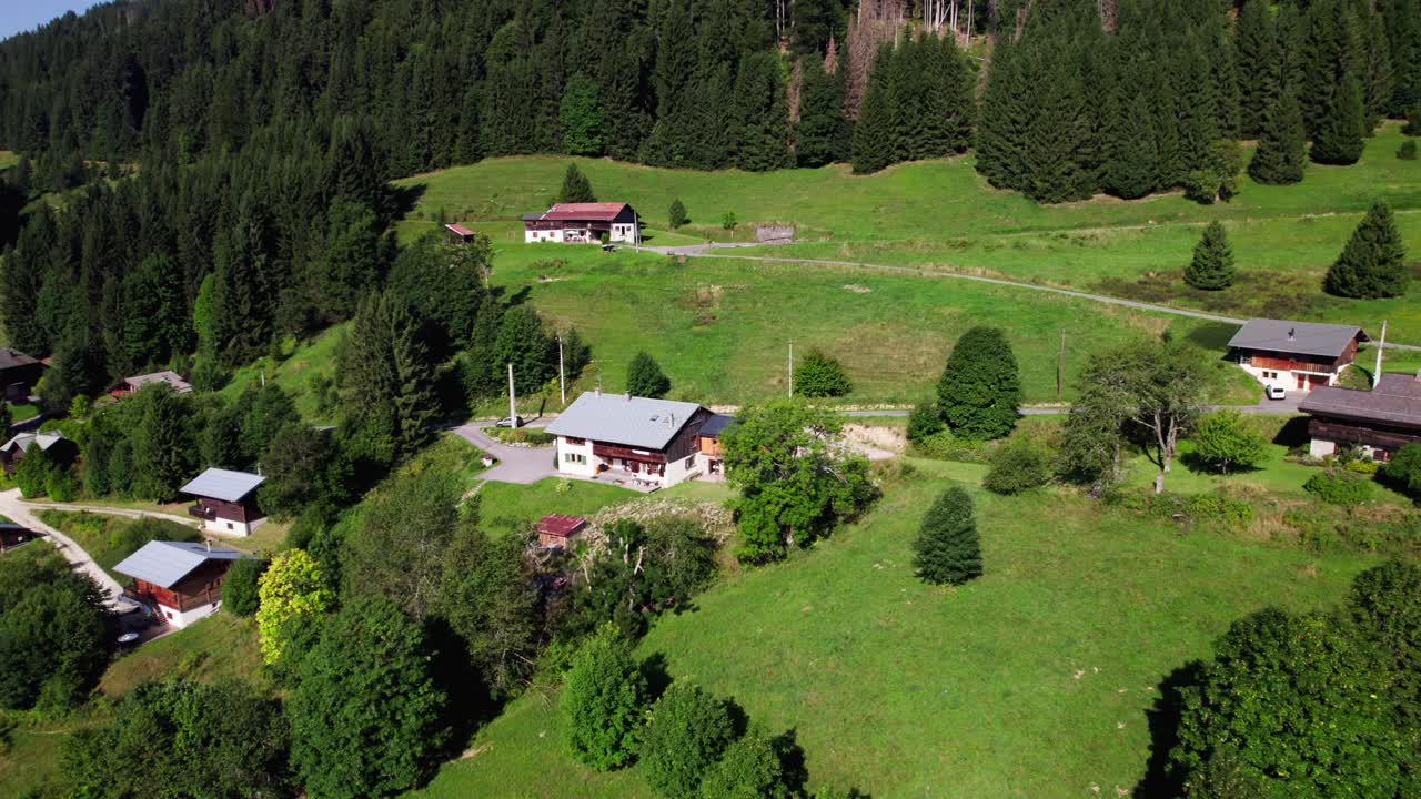 Aerial view of holiday winter sports region during summer with venues in lush greenery against the mountain side