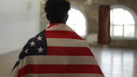 Boxer-Kommt-Mit-Amerikanischer-Flagge-Auf-Den-Schultern-In-Ein-Boxstudio