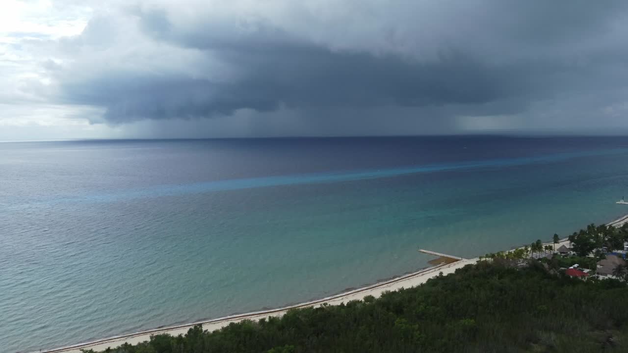 코즈멜 해변에서 폭풍우 구름이 터키즈색 바다 위로 다가오고 있다.