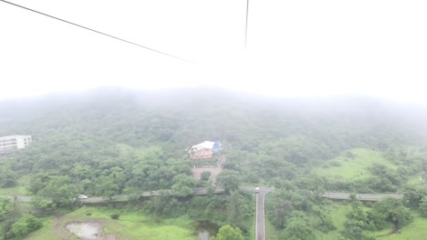 beautiful view from a ropeway car moving up the mountain on a cloudy day, cable car in the clouds