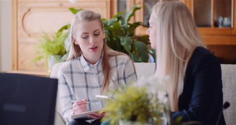 Female-Colleagues-Discussing-Business-Strategy-Office-Work-Businesswomen-Using-Digital-Tablet-