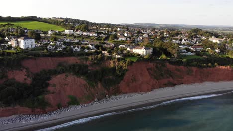 Plataforma-Rodante-Aérea-Sobre-Seaton-Beach-Y-Acantilados-Con-Casas-En-La-Parte-Superior