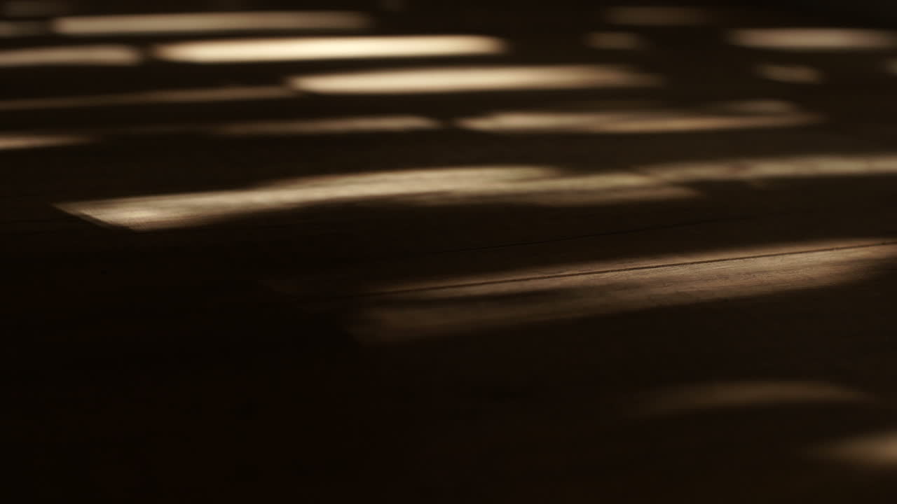 Sun shines through window shutters - creates moving shadows on floor