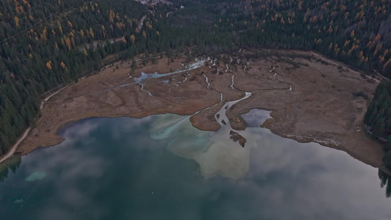 Vista aerea del Lago di Dobbiaco con foresta autunnale nelle Dolomiti, Italia