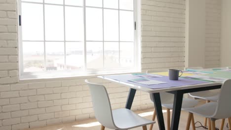 empty white creative office with documents and cup of coffee on table in slow motion