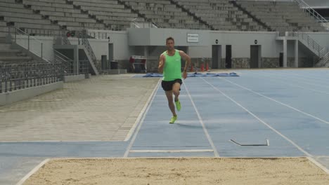 vista frontal de un atleta caucásico haciendo un salto de longitud