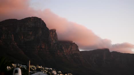 Sunset-time-lapse-shot-of-clouds-moving-over-mountain-as-light-fades-away-to-darkness