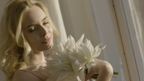 woman with flowers by the window