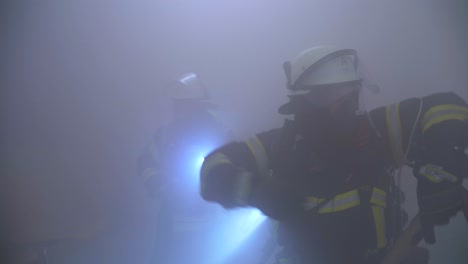 two firefighter in dark smokey room