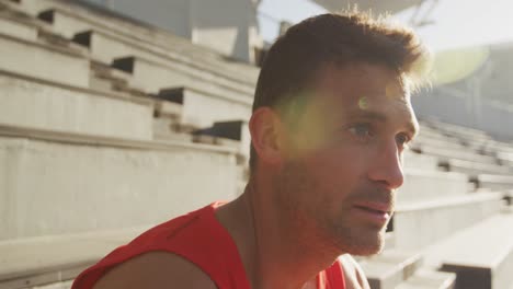 Side-view-of-thoughtful-caucasian-athlete-in-stadium