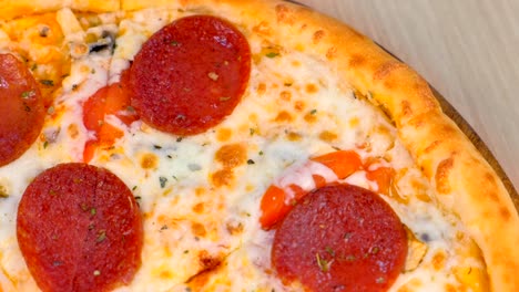 quater of slicing salami pizza on wooden board on the table. close-up top view.