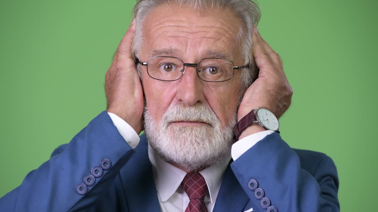 hombre de negocios barbudo y guapo contra un fondo verde.