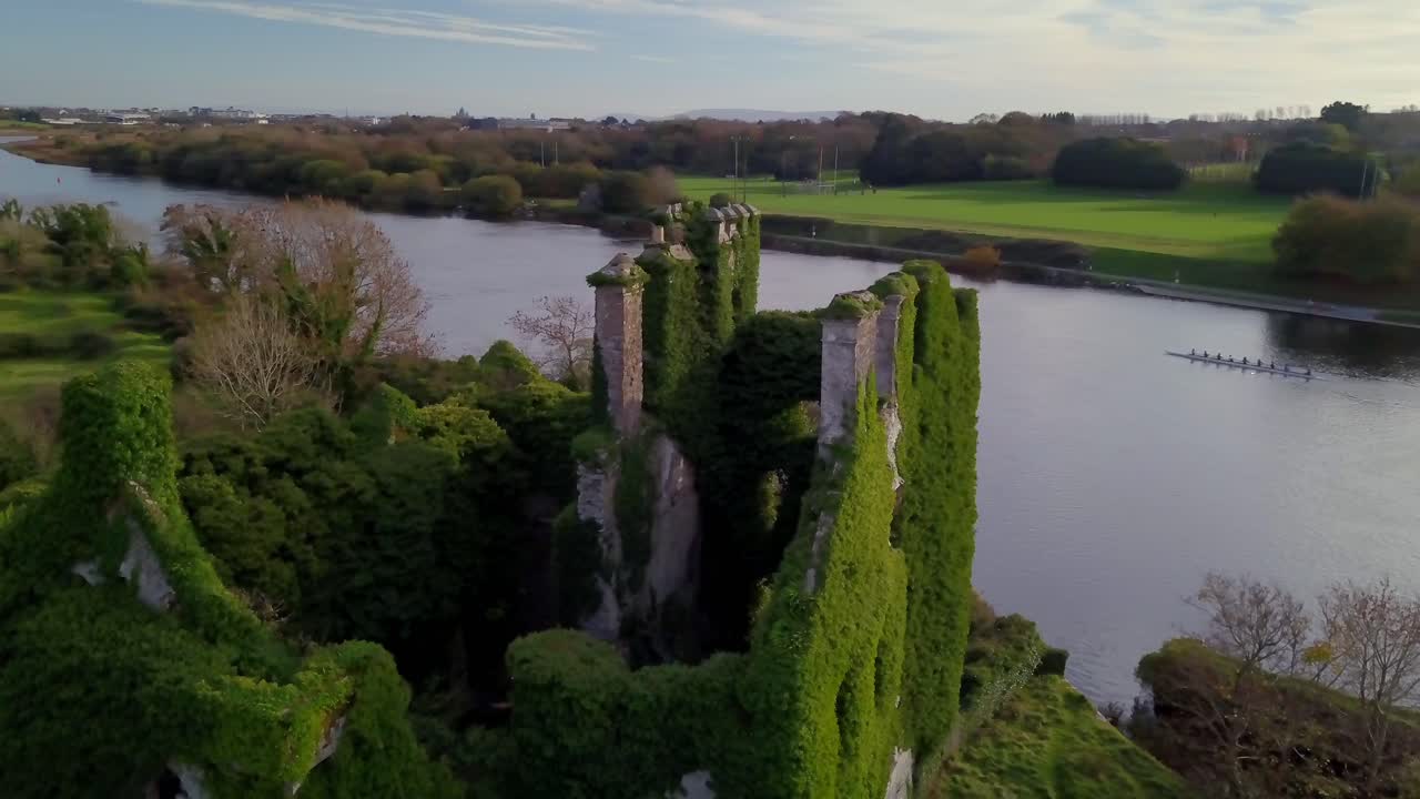 Orbita aerea intorno alla cima del Castello di Menlo che rivela il corso del fiume Corrib al tramonto