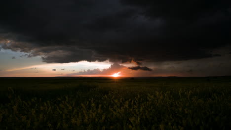 dramatic sunset through storm clouds over a field