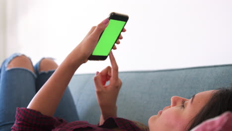 Close-Up-Of-Woman-Lying-On-Sofa-At-Home-Using-Mobile-Phone