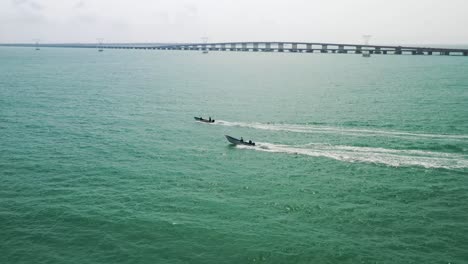 Drone-aerial-video-of-2-speed-boats-off-the-coast-of-the-Gulf-of-Mexico-at-sunset