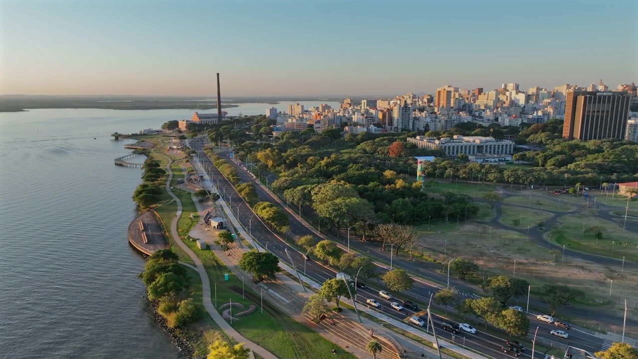 Skyline della città di Porto Alegre con parco fluviale e movimento di camion a destra al tramonto