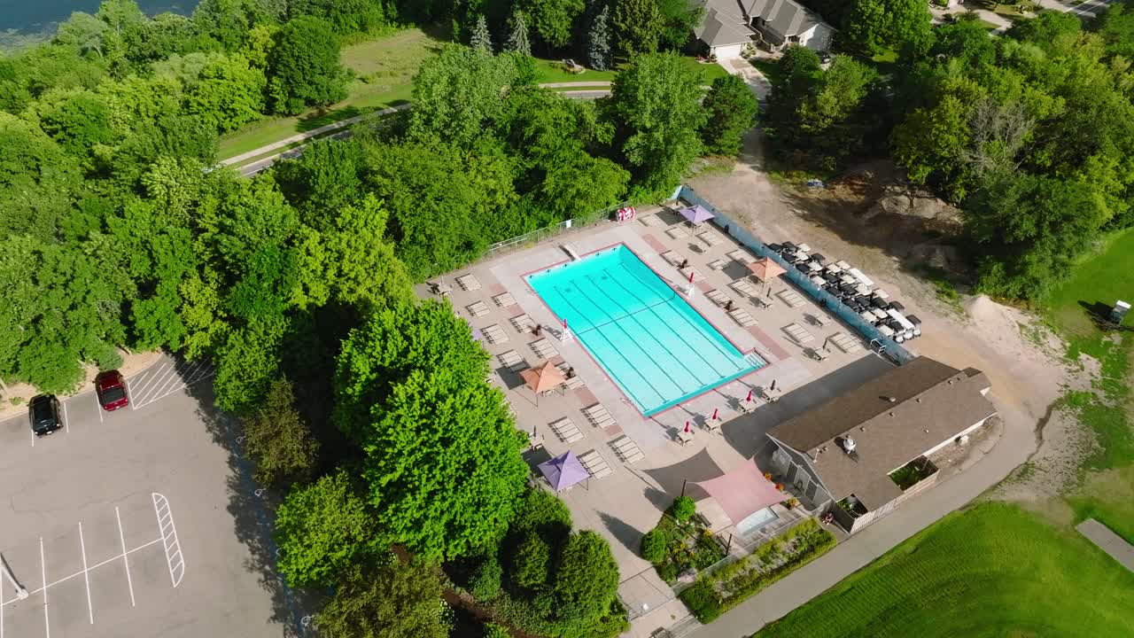 Drone shot of an outdoor public lap pool with bright blue water