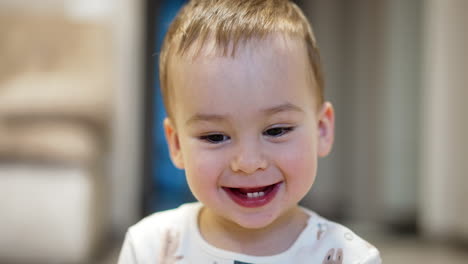 lovely caucasian toddler smiles adorably to the camera. portrait of a little boy in a good mood. close up.