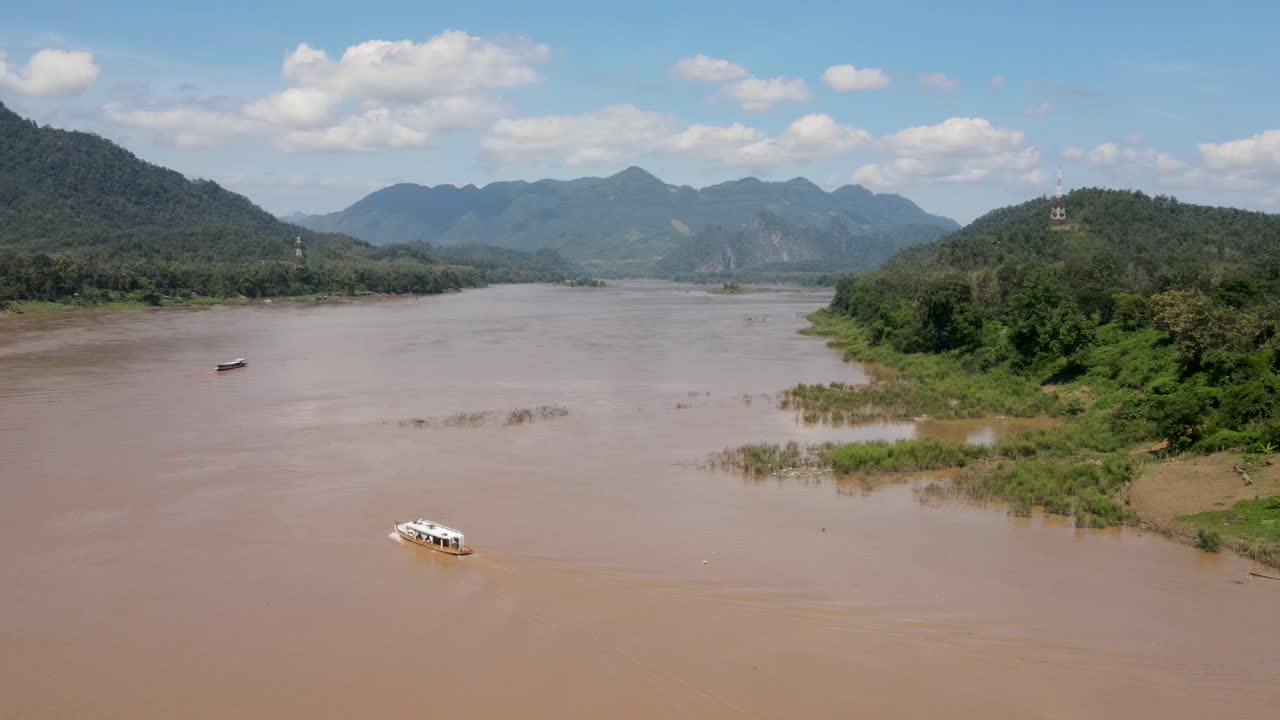 Vista aerea sul fiume Mekong in una giornata di sole con una barca fluviale che lo attraversa a Luang Prabang.
