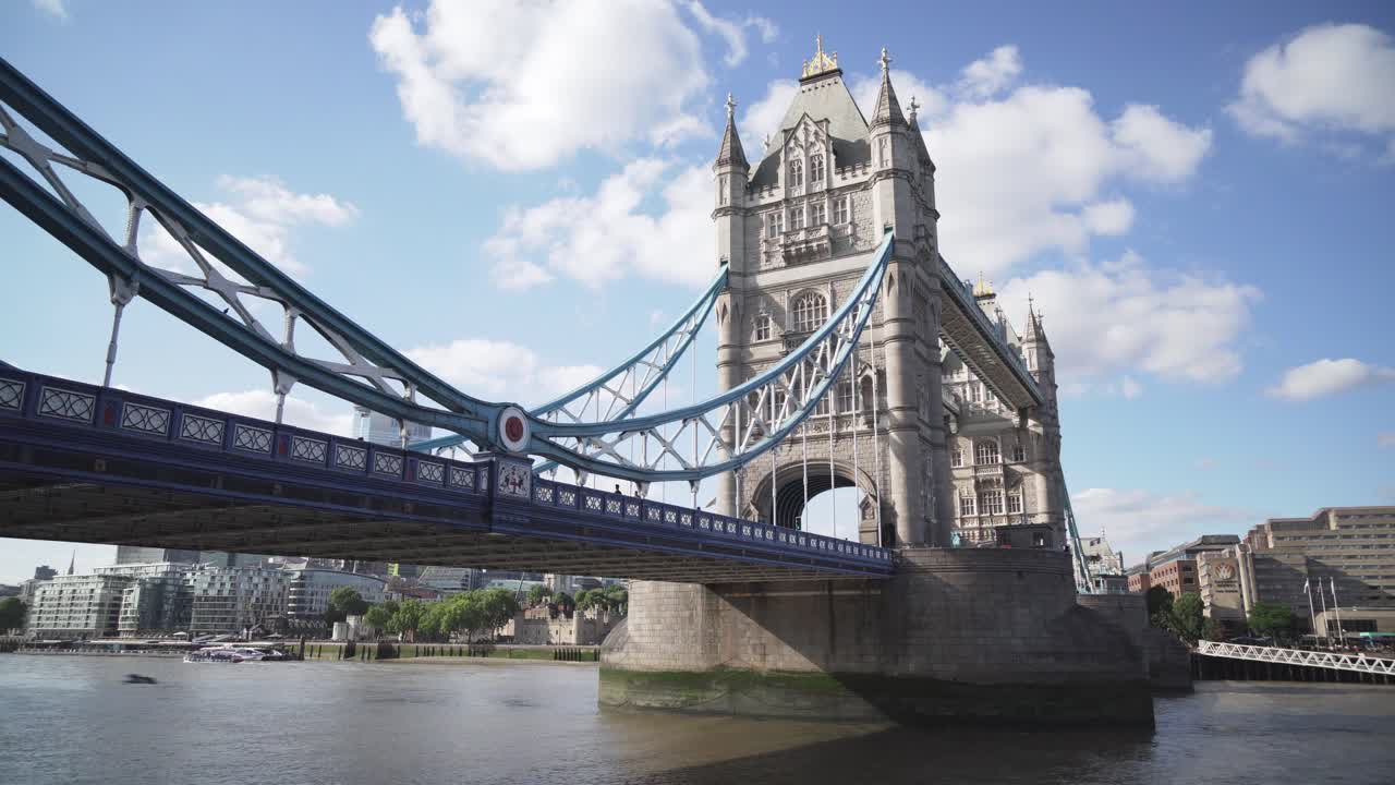 Side angle view of Iconic Tower Bridge in London with few cars and people, sunny day, cinematic shot