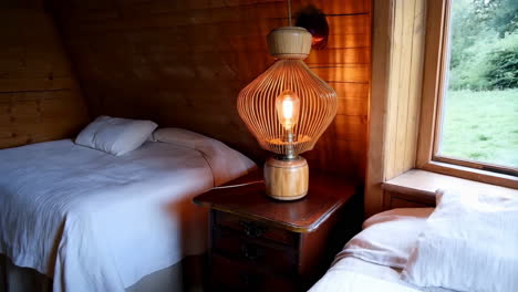 cozy rustic bedroom with wooden walls and unique lamp