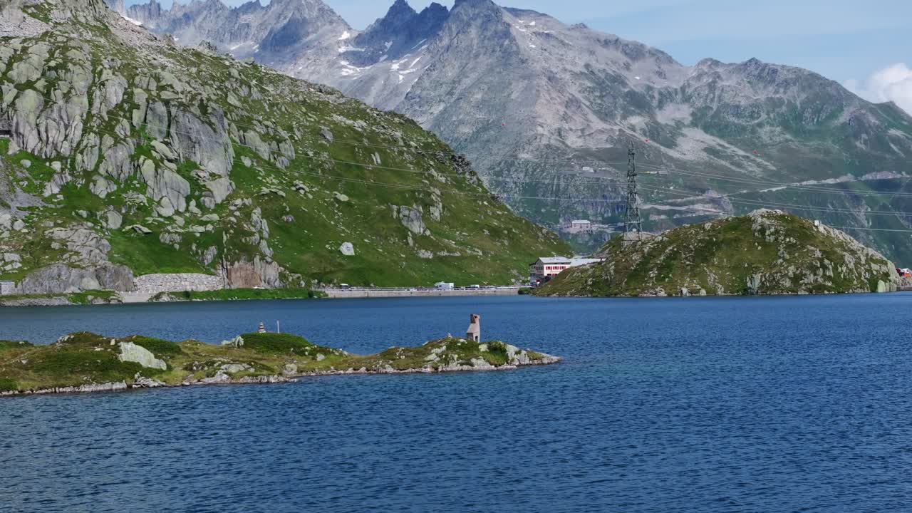 Aerial View of Totensee Lake surrounded by majestic Swiss mountains under a blue sky. Orbit Motion Shot