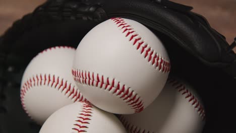 Close-Up-Overhead-Studio-Baseball-Still-Life-With-Balls-In-Catchers-Mitt-On-Wooden-Floor