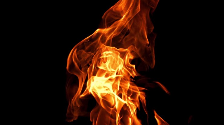 Fiamme arancioni e gialle vivaci che danzano su sfondo nero
