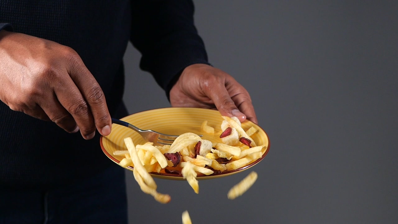 Slow Motion of French Fries and Toppings Falling from a Plate