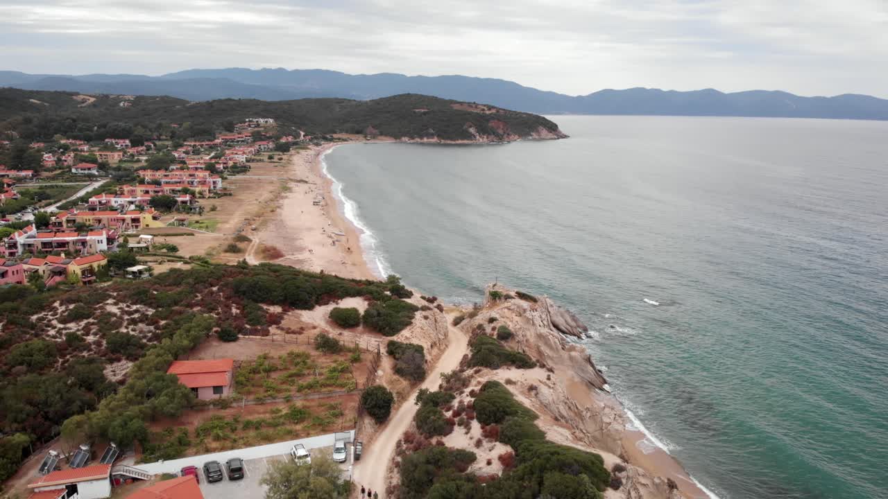 drone video sobre casas de verano arena larga playa olas personas cielo nublado día de verano