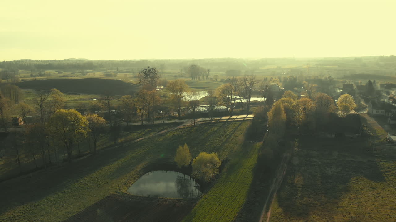 Bright sunset in rural area, stunning farm lands hit with gorgeous light, aerial