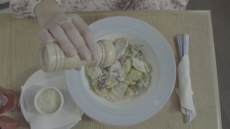 una mujer comiendo ensalada de césar.