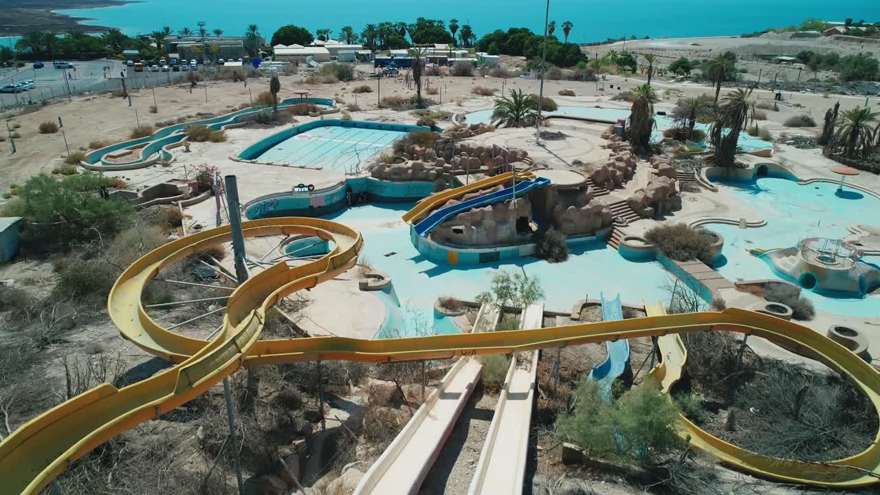 무인 항공기는 죽은 바다 앞 버려진 공원에서 워터 슬라이드를 촬영