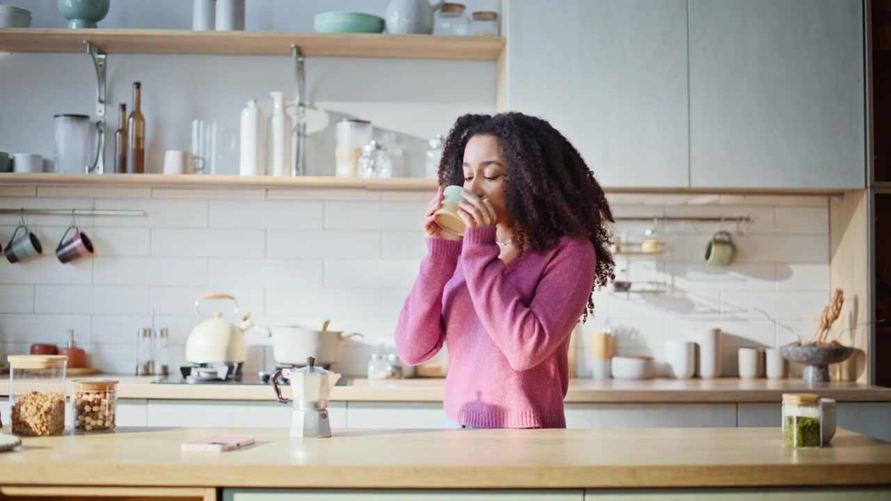Dreamy woman holding coffee cup standing modern kitchen interior closeup.