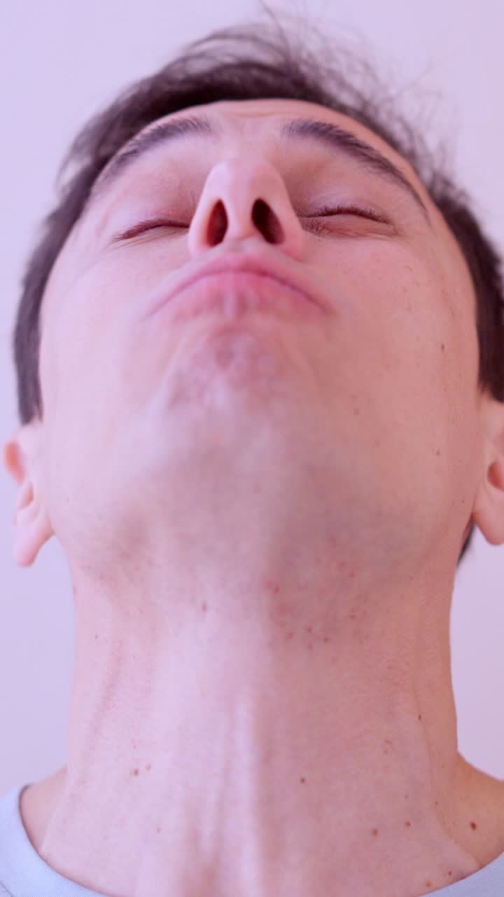 Man rinsing mouth with mouthwash in bathroom