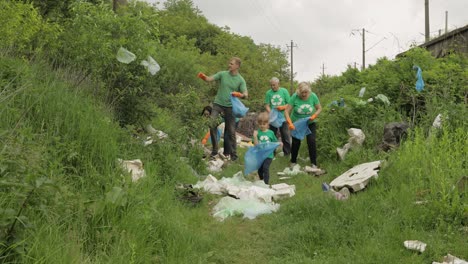 volunteer team cleaning up dirty park from plastic bags, bottles. reduce trash cellophane pollution