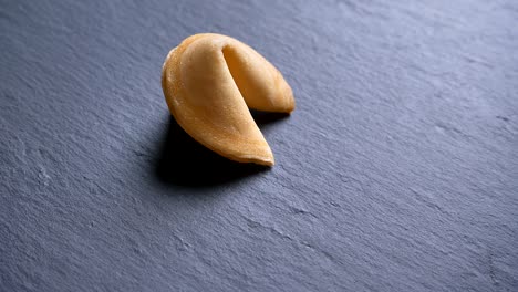 close-up circling around top shot of cookie with prediction spinning slowly on gray table background.