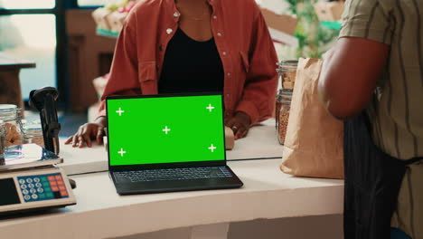 cliente comprando productos al lado de la pantalla verde en la computadora portátil