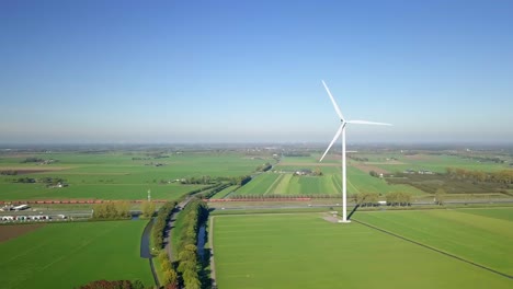 Aerial-drone-view-at-the-countryside-farmland-when-cargo-train-passing-by-in-the-Netherlands,-Europe