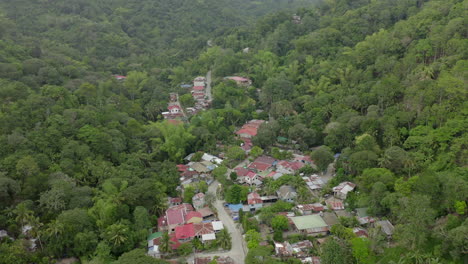 drone video from above with houses built in green jungle in a third world country